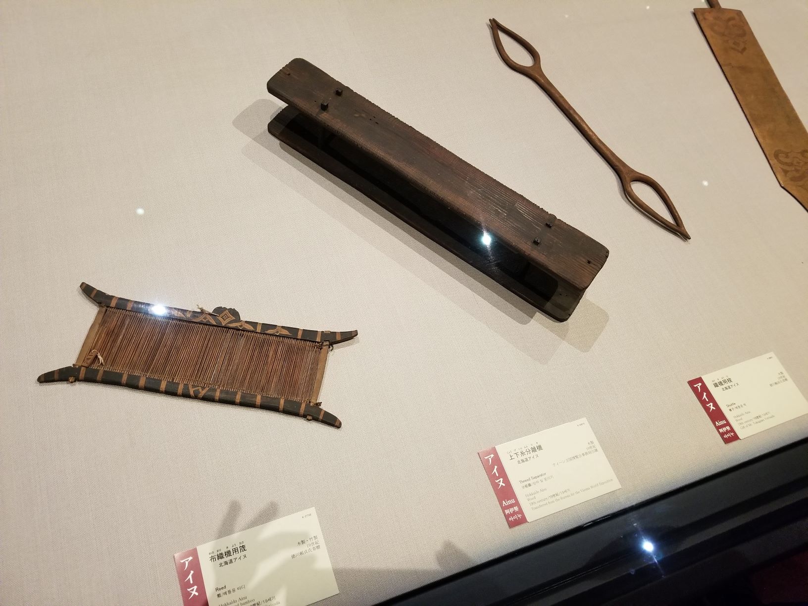 Various small Ainu tools displayed in a museum.